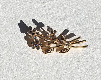 Broche antiguo con tallos de flores en metal dorado con diamantes azules, circa 1950.