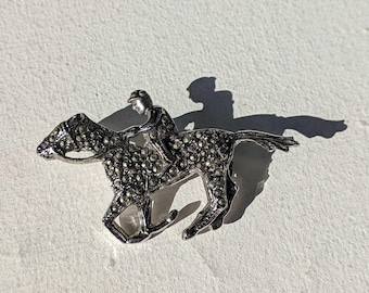 Broche antiguo de caballo y jinete con marcasita en tono plateado, circa 1950-60.
