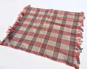 Poszewka na poduszkę z połowy XX wieku, tkana w kratkę w kolorze czerwonym, kremowym i czarnym, z frędzlami na końcach, z lat 50. i 60. XX wieku
