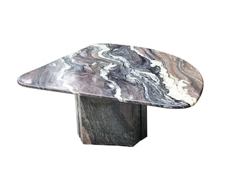 May include: A unique, abstract coffee table with a swirling, multi-colored marble top and a matching marble base.