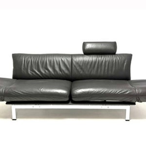 May include: A dark gray leather sofa with a matching pillow. The sofa has a chrome frame and a modern design.