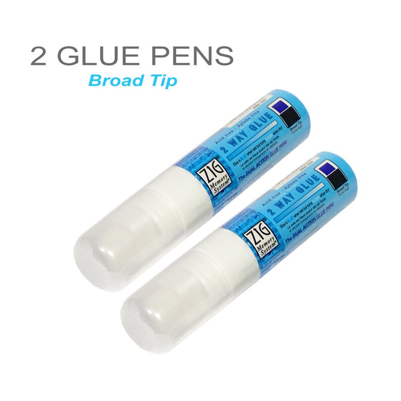 May include: Two white glue pens with blue labels that say "Zig Memory System 2 Way Glue The Dual Action Glue Pen" and "Acid Free Zig 2 Way Glue The Dual Action Glue Pen".