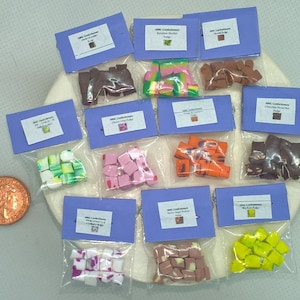 May include: Assortment of small bags containing various types of miniature candy fudge. Each bag has a label with the name of the fudge flavour, such as "Rainbow Sherbet" and "Chocolate Peanut Brittle".