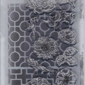 May include: Clear stamp and stencil set featuring floral and geometric designs. The set includes various flower and leaf stamps, along with a stencil with a geometric pattern. The packaging includes the text "STAMPERS ANONYMOUS" and "STAMPS/STENCIL".