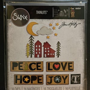 May include: A Sizzix Thinlits die set with a rustic theme. The set contains die-cut shapes of a moon, stars, clouds, houses, trees, and the words "PEACE," "LOVE," "HOPE," and "JOY." The package also includes the text "Jim Holtz."