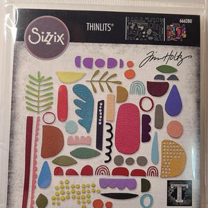 Pode incluir: Um conjunto de matrizes Sizzix Thinlits com 43 matrizes com uma variedade de formas geométricas e padrões em várias cores. O conjunto de matrizes foi projetado por Jim Holtz e inclui o texto "43 DIES | 43 MATRICES | 43 TROQUELES | 43 FUSTELLE | 43 ВЫРУБКИ | 43 STANZEN | 43 CORTANTES".