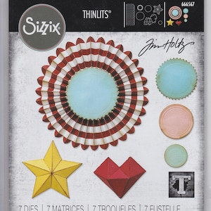 May include: A set of seven die-cut shapes for crafting, including a red and white striped circle, a blue circle, a pink circle, a yellow star, a red heart, and a blue circle with a white border. The package is labelled "Sizzix Thinlits" and "Jim Holtz".