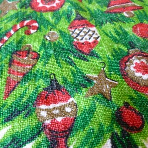 May include: A green Christmas tree fabric with red, white, and brown ornaments, candy canes, and stars. The fabric has a textured, woven look.