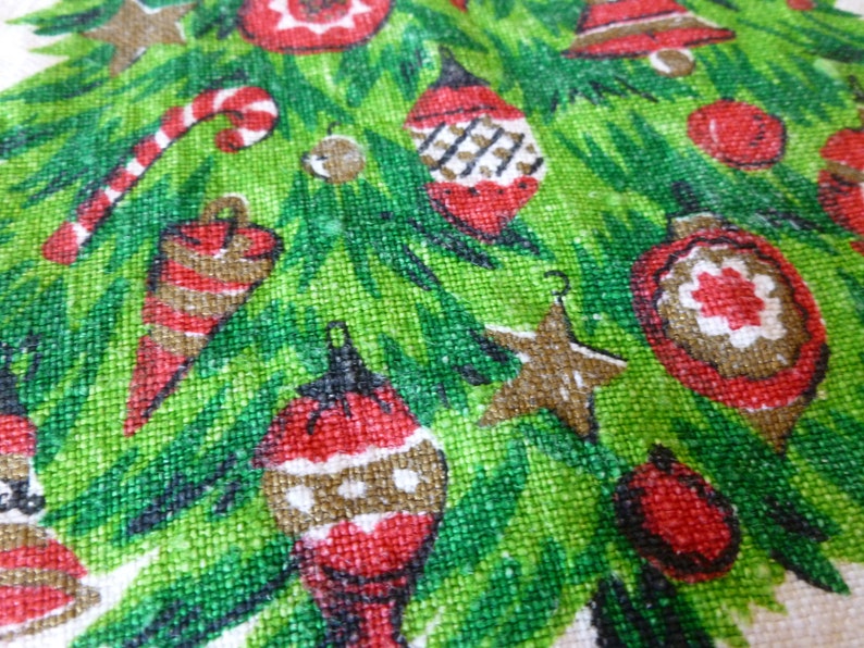 May include: A green Christmas tree fabric with red, white, and brown ornaments, candy canes, and stars. The fabric has a textured, woven look.