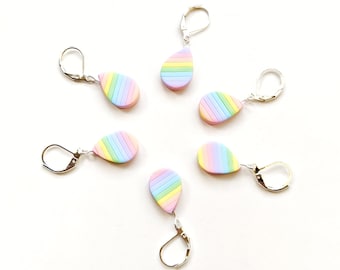 Può includere: Sei paia di orecchini a forma di lacrima a strisce arcobaleno con ganci d'argento. Gli orecchini sono realizzati in pasta polimerica e hanno uno schema di colori pastello.
