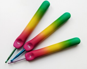 May include: Three rainbow-colored crochet hooks with green, yellow, and red gradients. The hooks are labeled with the numbers 3, 4, and 5.