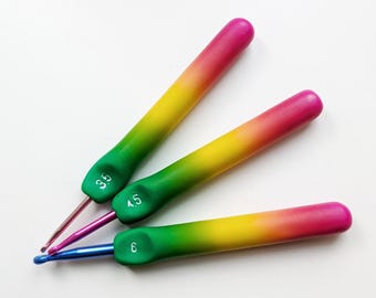 May include: Three crochet hooks with colorful handles. The handles transition from green to yellow to pink. The hook sizes are 3.5, 4.5, and 6. The hooks are made of metal and have different colored tips.