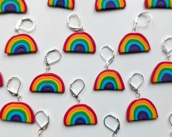 Può includere: Un set di orecchini arcobaleno con ganci d'argento. Ogni orecchino ha la forma di un arcobaleno con i colori rosso, arancione, giallo, verde, blu, indaco e viola.