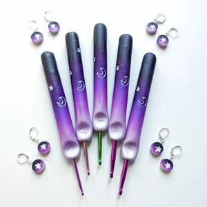 Può includere: Set di sei uncinetti viola e neri con un design a luna e stella. Gli uncinetti sono realizzati in argilla polimerica e hanno un effetto sfumato di colore.
