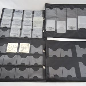 May include: Black storage binder with clear plastic pockets holding various die-cut shapes and embossing folders. The binder is open, displaying multiple pockets filled with shapes and the "Cuttlebug" logo.