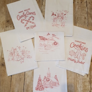 May include: Set of six red embroidered kitchen towels with various Christmas themes. The towels feature images of candy canes, a snowman, a pickup truck with a Christmas tree, a nativity scene, a church, and gingerbread cookies. The text on the towels reads "Hand Rolled Candy Canes 5¢ Each", "Christmas Cookies Freshly Baked", and "Merry Christmas".
