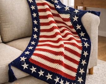 May include: A rectangular crochet blanket featuring a red, white, and blue pattern inspired by the American flag. The design includes horizontal red and white stripes bordered by a dark blue edge adorned with white crocheted stars and corner tassels.