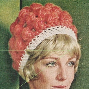 May include: A woman wearing a red crocheted hat with a white crocheted trim. The hat is a close-up and the woman is looking to the right. She is wearing a red crocheted top and has a gold earring in her left ear.