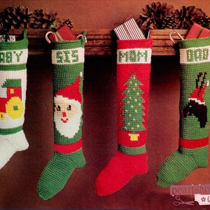 May include: Four handmade Christmas stockings in green, red, and white. Each stocking is personalized with names like "BABY", "SIS", "MOM", and "DAD". Designs include a train, Santa Claus, a Christmas tree, and a reindeer.