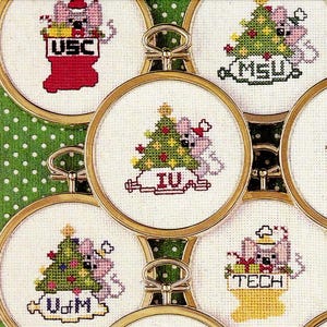 May include: A collection of embroidered Christmas ornaments. Each ornament features a mouse with a Christmas tree and a college or university name. The ornaments are in gold-colored hoops and are arranged on a green background.