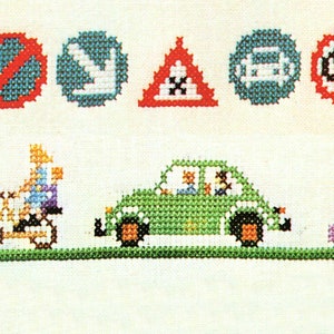 May include: Cross-stitch embroidery design featuring a green car with passengers, a person riding a bicycle, and a person riding a scooter. The design also includes various road signs, including a no entry sign, a left turn sign, a warning sign, a no parking sign, and a speed limit sign.