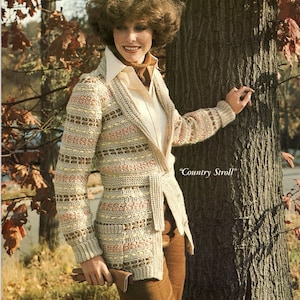 May include: A crocheted cardigan with a belted waist and a brown, beige, and pink color scheme. The cardigan is open in the front and has a V-neck. The text "Country Stroll" is visible in the image.