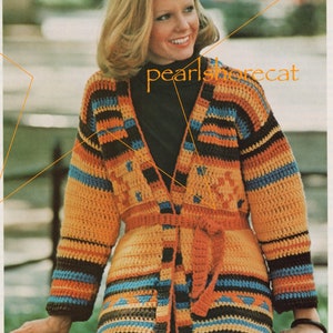 May include: A crocheted cardigan with a colourful striped pattern in shades of orange, brown, blue, and yellow. The cardigan has a tie belt and a V-neck.