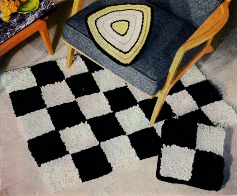 May include: A black and white checkered rug and matching pillow set. A triangular pillow with yellow, white, and black accents sits on a gray chair. The rug and pillow have a textured, shaggy appearance.