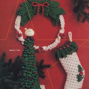 May include: A green and white Christmas wreath, a green Christmas tree, and a white stocking with red berries. The tree and stocking are made of yarn and the wreath is made of green yarn with a red bow.