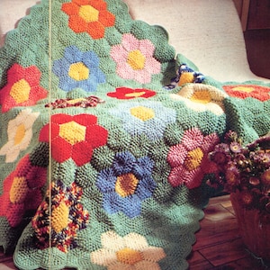 Pretty green hexagon motifs with colorful florals hexagon grannies to make flower clusters and a lovely crocheted blanket.