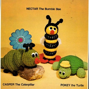 Könnte beinhalten: Gestoffte Spielzeuge aus Häkelgarn in Form einer Biene, einer Raupe und einer Schildkröte. Die Biene ist gelb und schwarz mit einer roten Nase und weißen Flügeln. Die Raupe ist grün mit schwarzen Augen und einem roten Mund. Die Schildkröte ist grün mit einer gelben Schale und schwarzen Augen. Die Spielzeuge befinden sich auf einem gelben Hintergrund mit dem Text "NECTAR The Bumble Bee", "CASPER The Caterpillar" und "POKEY the Turtle" unter jedem Spielzeug.