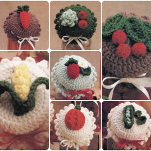 May include: Set of nine crocheted jar lids with various fruit and vegetable designs. The lids are made in white, brown, green, and red yarn. The designs include a carrot, a strawberry, a bunch of cherries, a corn cob, a cabbage, and an apple.