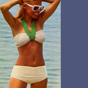 May include: A white crocheted bikini top and bottom with a green crocheted strap. The bikini is being worn by a person with blonde hair and sunglasses.