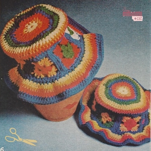 May include: Two crocheted hats in a rainbow color pattern with flower designs. The hats are made with blue, green, yellow, orange, and red yarn.