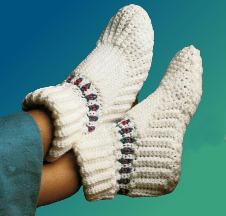 May include: White crocheted slipper socks with a pink and teal trim. The socks are folded down at the top.