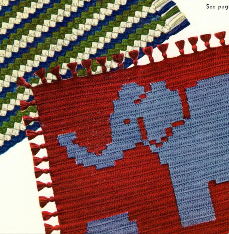 Op de afbeelding: Twee gehaakte vierkanten met franjes. Een vierkant is rood met een blauw olifantenontwerp. Het andere vierkant is een groen, wit en blauw geometrisch patroon. "Zie pagina..." is zichtbaar in de rechterbovenhoek.