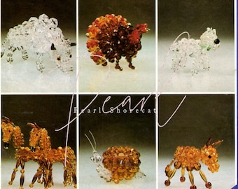May include: Six beaded animal figurines, including a white bull, a brown turkey, a white dog, a brown horse and foal, a brown snail, and a brown donkey. The figurines are made with small glass beads and are displayed on a white background.
