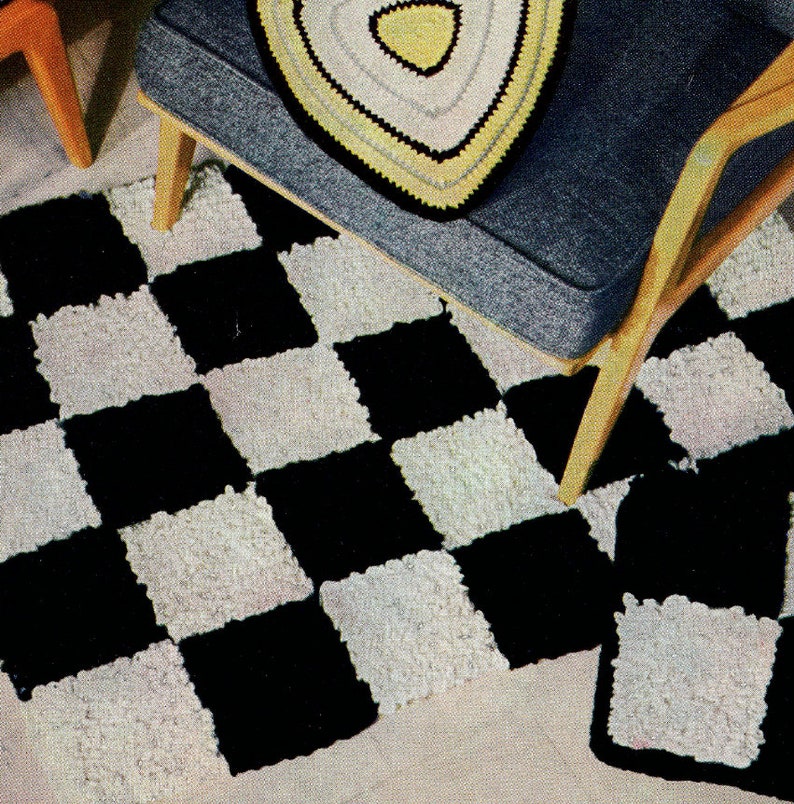 May include: A black and white checkerboard rug with a matching square accent rug. The rug is made of a textured material. A blue chair with a triangular, crocheted pillow is in the background.