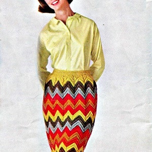 Peut inclure: Une femme porte une chemise jaune &agrave; manches longues et une jupe &agrave; motifs chevrons multicolores. La jupe pr&eacute;sente un motif en zigzag rouge, jaune, marron et argent&eacute;. La jupe arrive au genou.