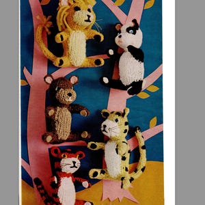 May include: A collection of handmade knitted animal toys, including a lion, panda, bear, tiger, and leopard. The toys are in various colors, such as yellow, black, white, brown, and red. They are arranged on a blue background with pink tree branches.