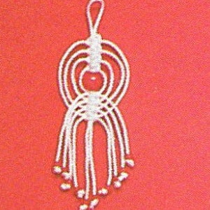 May include: White macrame keychain with a red bead in the center and a loop at the top.