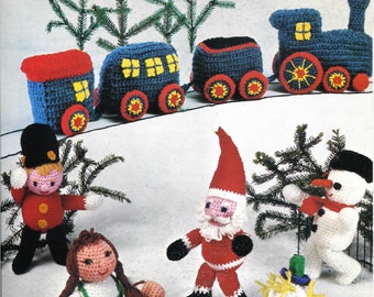 May include: A set of crocheted Christmas ornaments including a train, a snowman, Santa Claus, a girl, and a toy soldier. The train is blue with red and yellow accents. The snowman is white with a red scarf and black hat. Santa Claus is wearing a red suit with a white trim and a white beard. The girl is wearing a green dress with a white apron. The toy soldier is wearing a red coat with yellow buttons and a black hat.