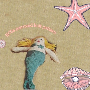 May include: A knitted mermaid doll with blonde hair and a blue tail. The doll is lying on a sandy beach background with a pink starfish and a seashell with a pearl.