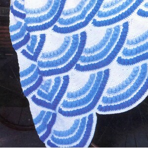 May include: A crocheted blanket with a blue and white wave pattern.