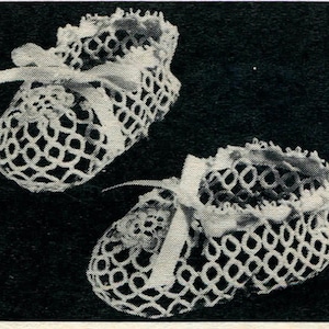 May include: A pair of white crocheted baby booties with white satin ribbon ties.