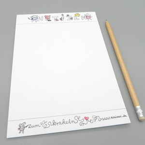 Può includere: Un blocco note bianco con illustrazioni di cartoni animati colorati e testo in alto e in basso. Una matita di legno con una gomma grigia è appoggiata a destra. Il blocco note è vuoto, pronto per gli appunti.