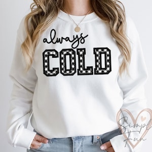 May include: White sweatshirt with black and white checkered text that reads "always COLD".
