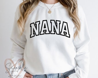 May include: White sweatshirt with black text that reads "NANA" in a collegiate font.