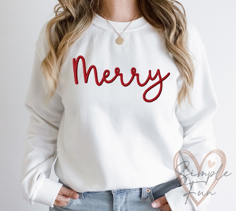 Pu&ograve; includere: Felpa bianca con una scritta "Merry" ricamata in rosso sul davanti.
