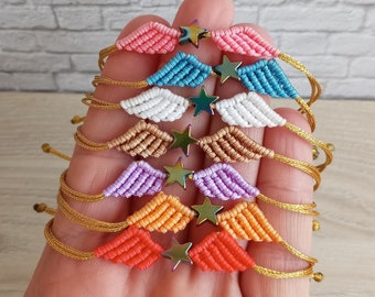May include: A set of six colourful friendship bracelets with gold thread and star-shaped charms. The bracelets are stacked on top of each other, with the colours ranging from pink to orange.